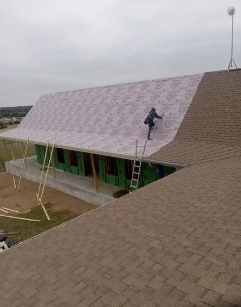Worker preparing underlayment for a metal roof installation in Hialeah Gardens